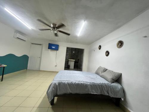 a bedroom with a bed and a ceiling fan at Depa tipo estudio cerca del mar y en la ciudad en Puerto Progreso in Progreso