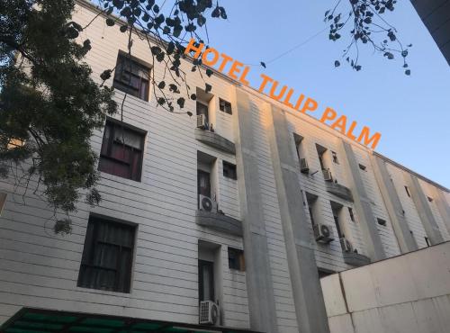 un edificio blanco con un cartel encima en Tulip Palm en Jaipur