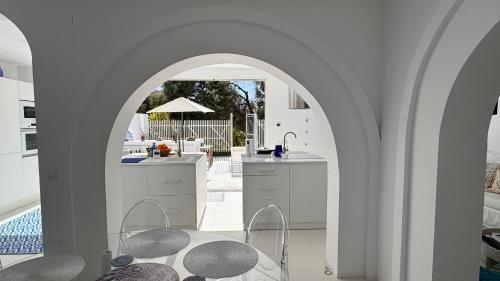 een boog in een keuken met een tafel en stoelen bij Casa Blu Marbella in Marbella