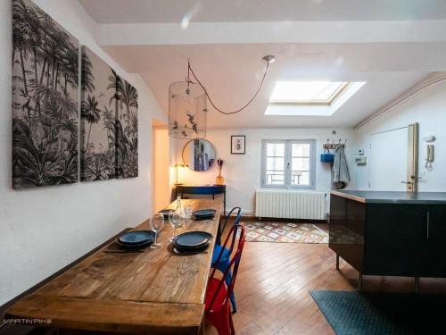 une salle à manger avec une table en bois et des chaises dans l'établissement L'ardoise - Climatisation cœur de ville, à Montpellier