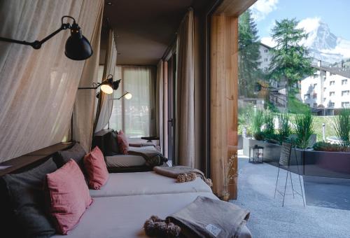 a row of beds in a room with a balcony at CERVO Mountain Resort in Zermatt