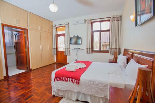 a bedroom with a large bed with a red blanket at Lidia's Place Guest House in Maputo