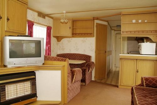 弗瓦迪斯瓦沃沃的住宿－Camping Nadmorski，带电视的小型客厅和厨房