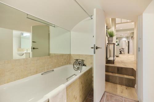 a bathroom with a tub and a sink at The Bayswater Gardens - Bright 3BDR Home in London