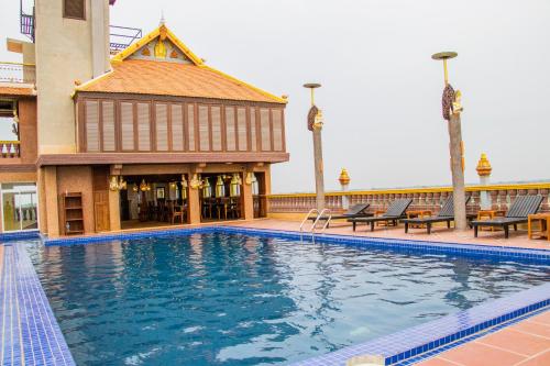 a large swimming pool in front of a building at Puok Hotel in Phumĭ Puŏk Chăs
