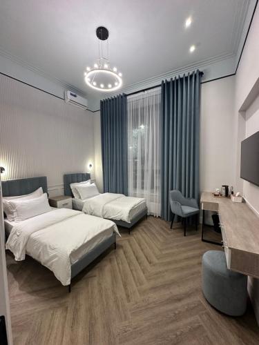 Five's Hotel Astana في أستانا: غرفة فندقية بسريرين ومكتب