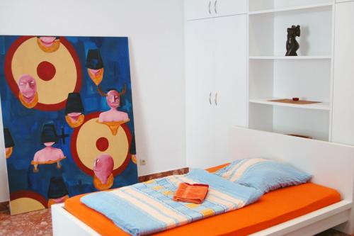 ein Schlafzimmer mit einem Bett mit einer orangen und blauen Decke in der Unterkunft ApartInn in Mannheim