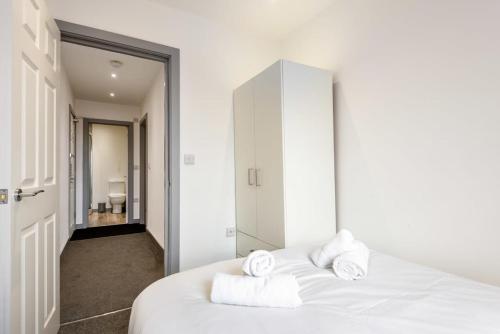 Contemporary Budget 1 Bed Apartment in Central Doncaster في دونكاستير: غرفة نوم بسرير ابيض عليها مناشف