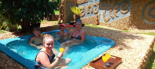 a group of people sitting in a swimming pool at Atha Safari Resort & Riverside Camping in Udawalawe