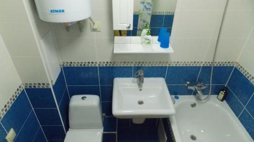 een badkamer met een wastafel, een bad en een toilet bij Svetlana's Apartments in Sumy