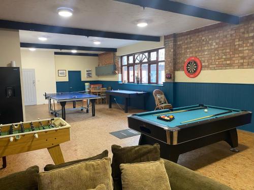 a billiard room with two pool tables and couches at The Stables in Tunstead