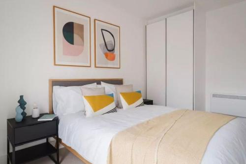 een slaapkamer met een groot wit bed met gele kussens bij Comfort by Mertru in Birmingham