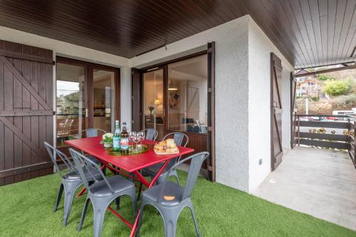 - une table et des chaises rouges sur la terrasse dans l'établissement Bel Apt Terrasse à 2 pas du Lac, à Sévrier
