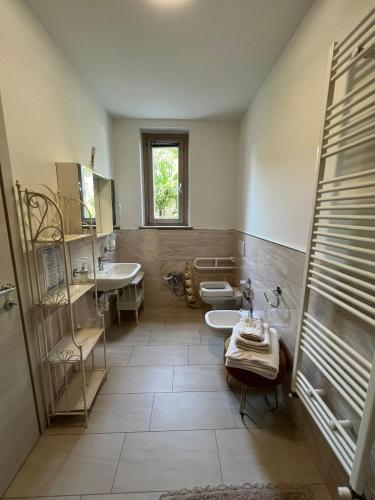 a bathroom with two sinks and a toilet and a window at Agriturismo le Fontanelle da Valente in Montichiari