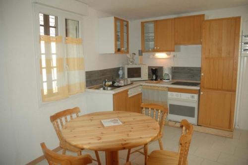une cuisine avec une table et des chaises en bois ainsi qu'une table, une table et des chaises dans l'établissement Gtes aux Portes de lEure Les Tournesols, à Vernon