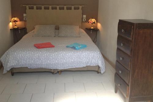 une chambre avec un lit avec deux pantoufles dessus dans l'établissement Gtes aux Portes de lEure Les Tournesols, à Vernon