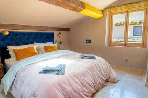 une chambre avec un grand lit avec une tête de lit bleue dans l'établissement Entire townhouse in the heart of the village, à Valbonne