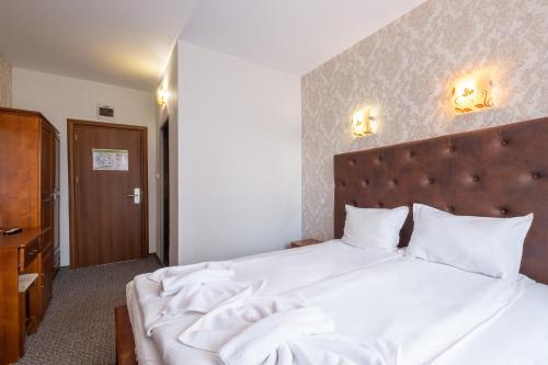 a bedroom with a large bed with white sheets at Katalina SPA Resort in Tsigov Chark
