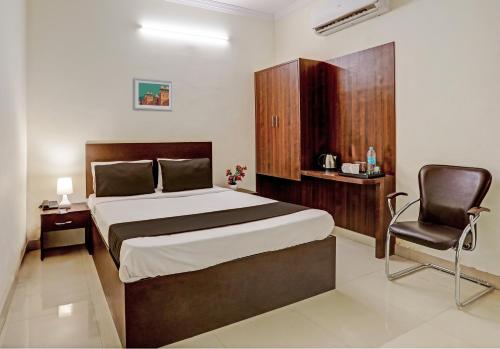 ein Schlafzimmer mit einem großen Bett und einem Stuhl in der Unterkunft OYO Flagship 35467 Shiridi Residency Near Birla Mandir in Hyderabad