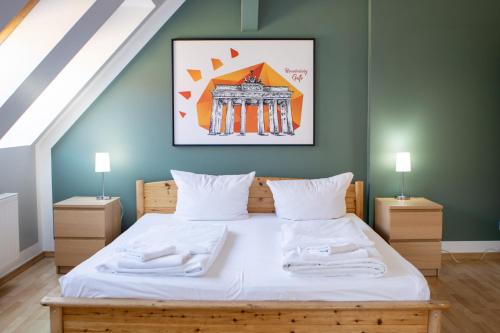 a bedroom with a large bed with white sheets at St Christopher's Berlin - Alexanderplatz Apartments in Berlin