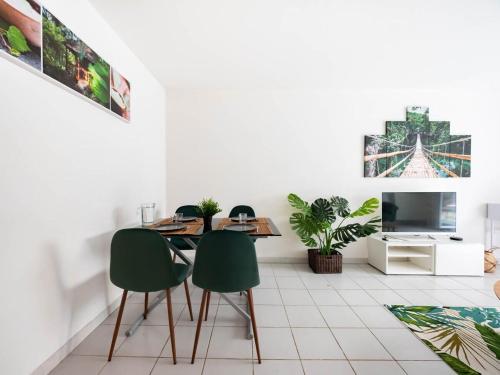 - un salon avec une table et deux chaises vertes dans l'établissement Le Messidor - Terrasse Rives du Lez, à Montpellier