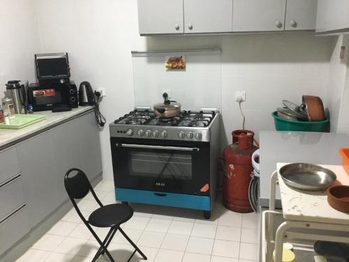 a kitchen with a stove and two chairs in it at Dubai NorthStar Hostels in Dubai