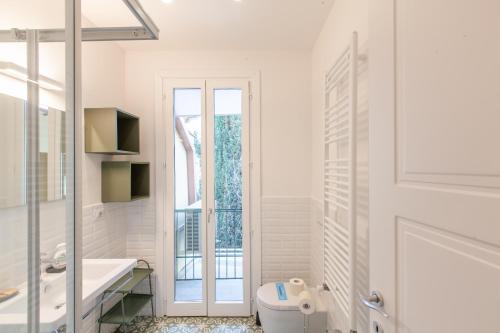 a white bathroom with a toilet and a sink at Santa Maria Novella Apartment in Florence