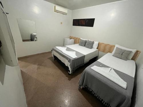 a room with two beds and a mirror at Pousada Maré Alta in Maceió