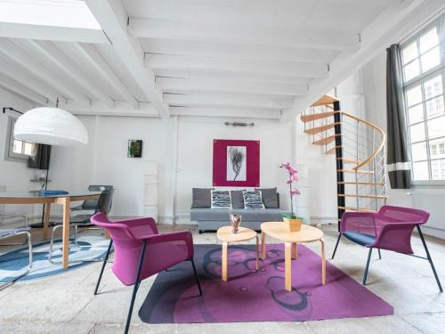 - un salon avec des chaises violettes et une table dans l'établissement Le pianiste - Climatisation en coeur de ville, à Montpellier