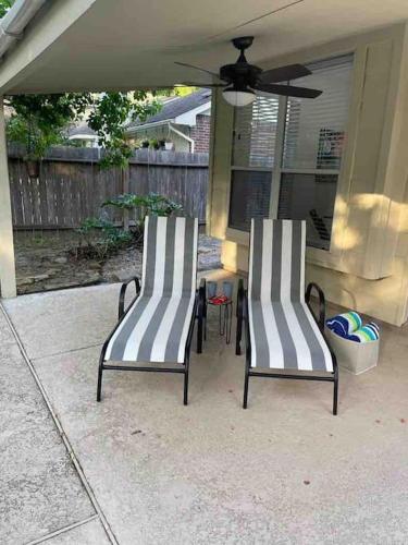 two chairs sitting next to a table on a patio at Lovely Woodlands home w/heated pool and spa! in Spring