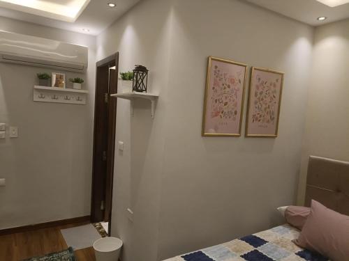 a bedroom with a bed and two pictures on the wall at حان الوقت الأن للاستمتاع بالهدوءبشقةفندقية متميزة بأطلالة على نيل الزمالك in Cairo