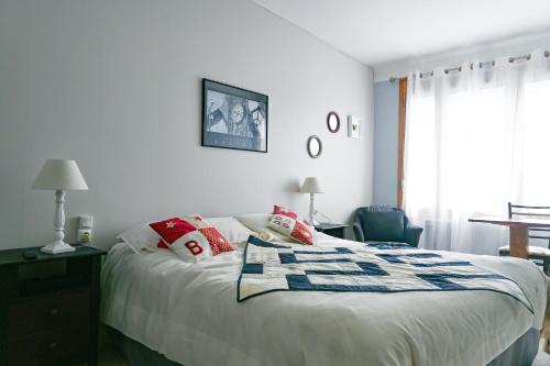 1 dormitorio con cama, mesa y ventana en Le Relais du Coustoubi, en Campouriez