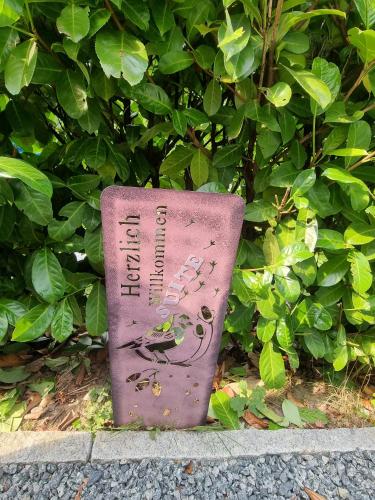 a sign sitting on the ground in front of a bush at likehome Suite in Buchholz in der Nordheide