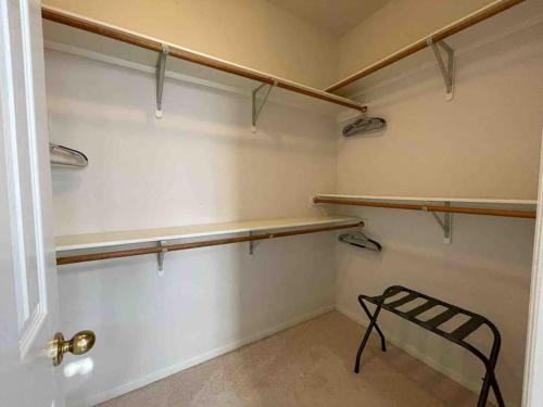 a walk in closet with wooden shelves and a bench at Lovely Woodlands home w/heated pool and spa! in Spring