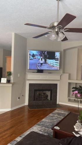 a living room with a tv and a fireplace at Lovely Woodlands home w/heated pool and spa! in Spring