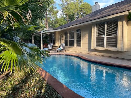 a swimming pool in front of a house at Lovely Woodlands home w/heated pool and spa! in Spring
