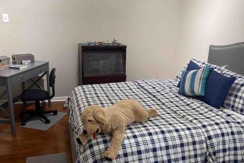 a stuffed dog laying on a bed in a bedroom at Lovely Woodlands home w/heated pool and spa! in Spring