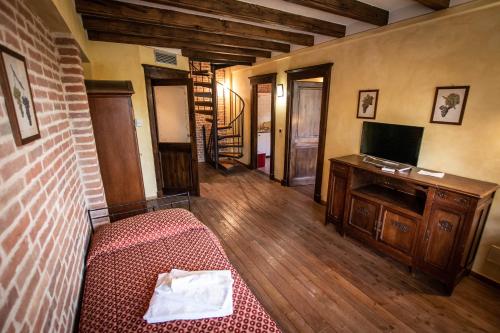 - une chambre avec un lit et une télévision dans l'établissement AGRITURISMO VALDISPINSO, à Santa Vittoria dʼAlba