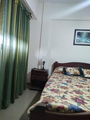 um quarto com uma cama e cortinas verdes em San Clemente frente al mar con cochera em San Clemente del Tuyú