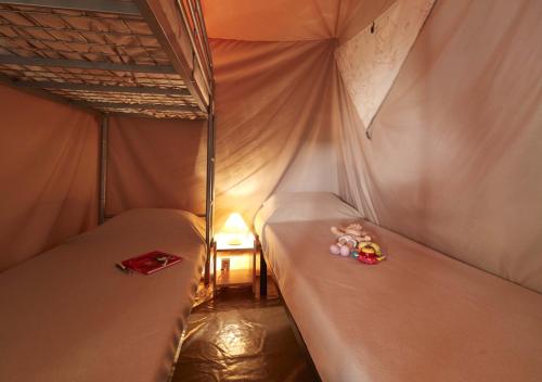 two beds in a tent with stuffed animals on them at Camping Le Both d'Orouet in Saint-Jean-de-Monts