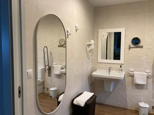 La salle de bains est pourvue d'un lavabo et d'un miroir. dans l'établissement TOURIÑÁN MAR, à Muxía