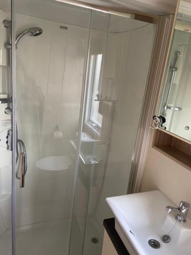 a bathroom with a shower and a sink at Otters Rural Retreat - Private Hot-Tub & Free Golf for guests included in Swarland