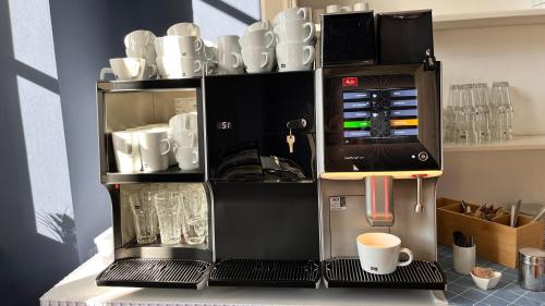 een koffiezetapparaat op een aanrecht met mokken en kopjes bij Schloss Schlemmin in Schlemmin