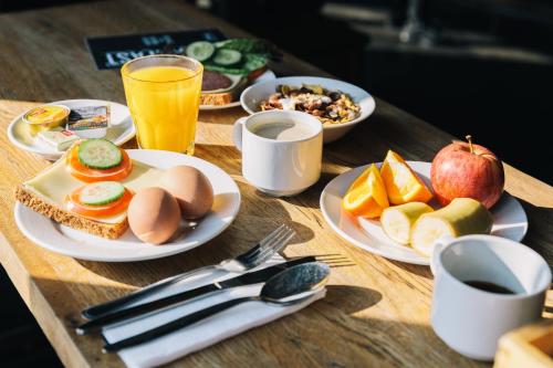 una mesa de madera cubierta con platos de comida y bebida en St Christopher's Apartments en Berlín