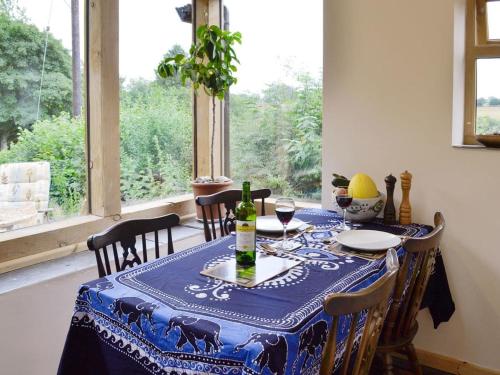 a dining room table with a blue and white table cloth at Hafotty Fach in Llanfyllin