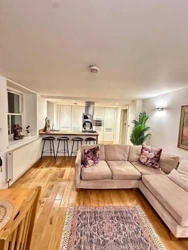 a living room with a couch and a kitchen at Opulent oasis in London in London