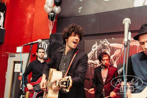 un grupo de hombres en un escenario con una guitarra en St Christopher's Apartments, en Berlín