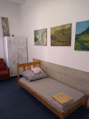 łóżko w pokoju z obrazami na ścianie w obiekcie Hostel Kwadrans w mieście Gliwice