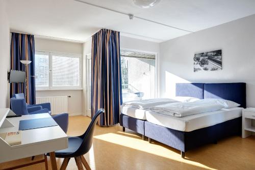 1 dormitorio con cama, escritorio y silla en Gästehaus Lazarus, en Berlín