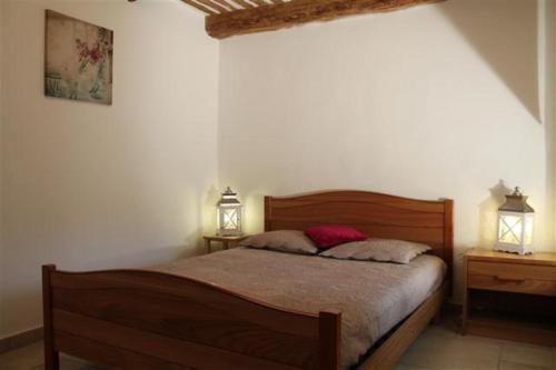 1 dormitorio con 1 cama de madera y 2 mesitas de noche en Gîte de la font d'Arlane, en Viviers